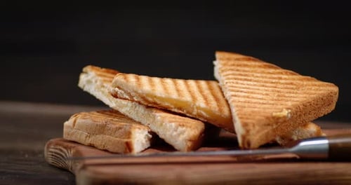 Die gebratenen Brotstücke auf dem Brett rotieren. Auf einem schwarzen Hintergrund