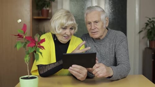 Senior Couple Using Tablet Device in Home