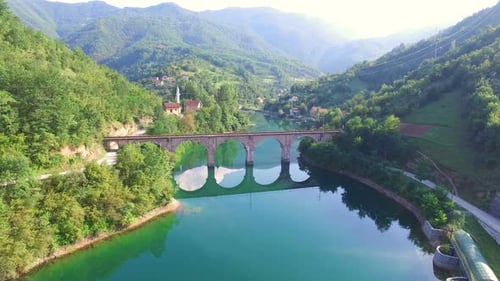 Flug über Fluss und alte Steinbrücke in Bosnien
