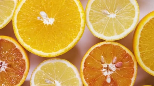 Fresh Cutted Yellow Lemons Oranges and Red Oranges Spin on Table Top Down View