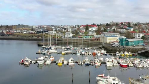 Flying Over Boats Docked At Marina With Traffic Driving On Seaside Road In The Background. - aerial