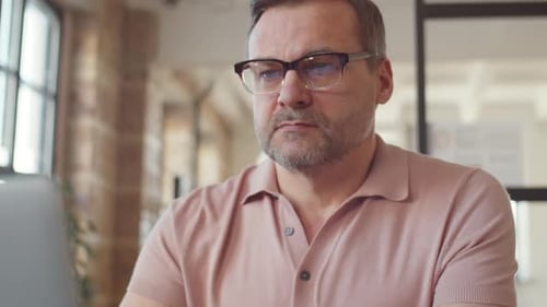 Mature Businessman Using Laptop at Office Desk