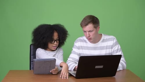 Child and Adult Use Technology at Desk