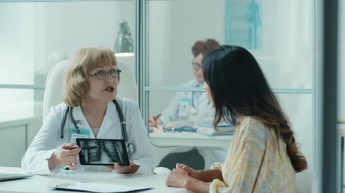 Doctor Explains X-Ray to Patient in Modern Office