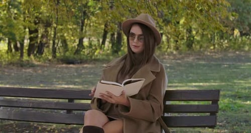 Woman Reading a Book in Autumn Park