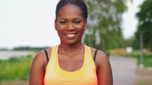 Woman Smiling in Park with Athletic Build