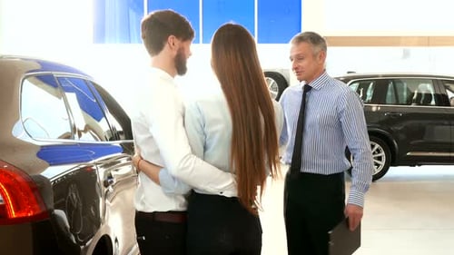 Salesman Consults Young Couple at the Car Dealership