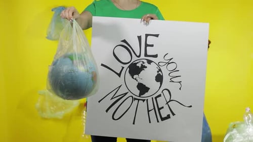 Mujer irreconocible con póster de protesta y globo terráqueo en paquete de plástico. Ecología y contaminación