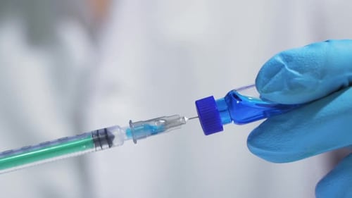 Der Arzt nimmt eine Spritze für den Coronavirus-Impfstoff