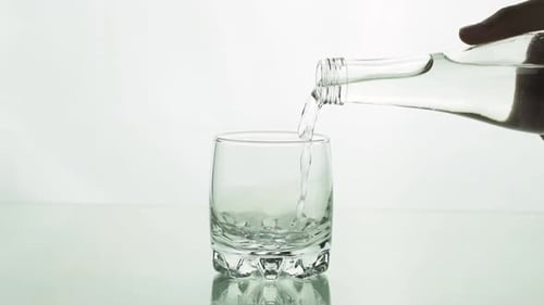 Pouring Clear Liquid into a Drinking Glass