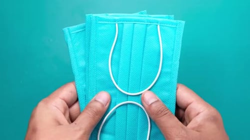 Man Hand Holding Surgical Face Mask, Close Up