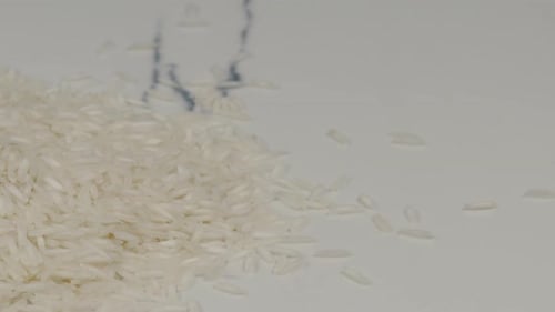 Uncooked White Rice Pouring on Clean White Surface