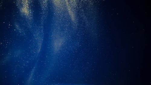 Golden Glittering Dust Swirls on Dark Blue Background