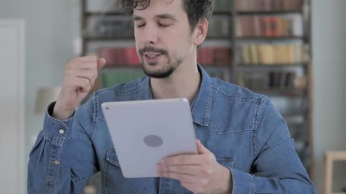 Young Man with Tablet Showing Disappointment Indoors