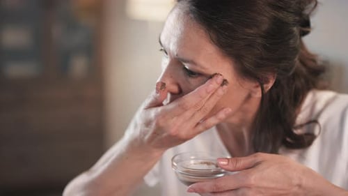 Woman Applies Facial Scrub Treatment in Home