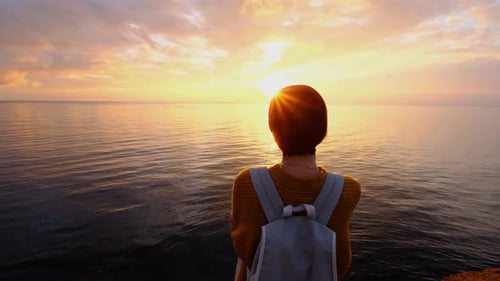 Person with Backpack at the Ocean During Golden Hour