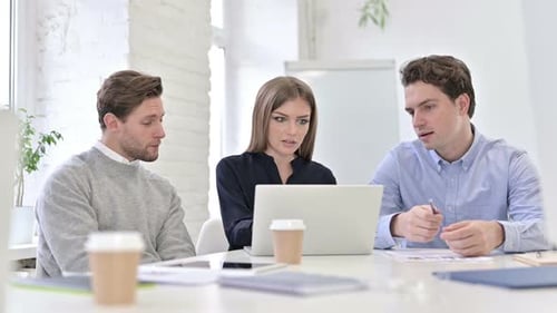 Attractive Startup Team Discussing and Working on Laptop