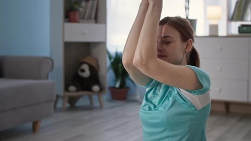 Girl in Sportswear Performs Breathing Exercises to Relax Muscles and Body After Exercise at Home in