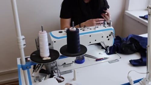 Woman Sewing Blue Fabric at Sewing Machine