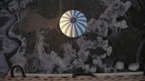 Hot air balloons fly over the mountainous landscape of Cappadocia, Turkey.