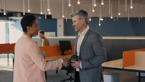 Business Professionals Shaking Hands in Modern Office