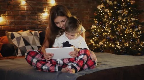 Children Watching Tablet by Christmas Tree