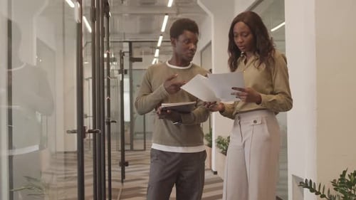 Colleagues Discuss Documents in Modern Office Setting