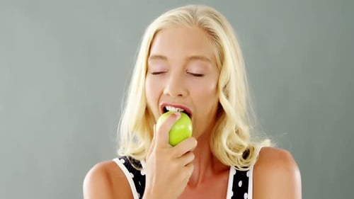 Portrait of beautiful woman eating green apple