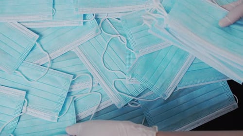 Surgical Masks Piled Up on Black Surface