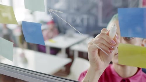 Woman Drawing on Glass Wall in Office