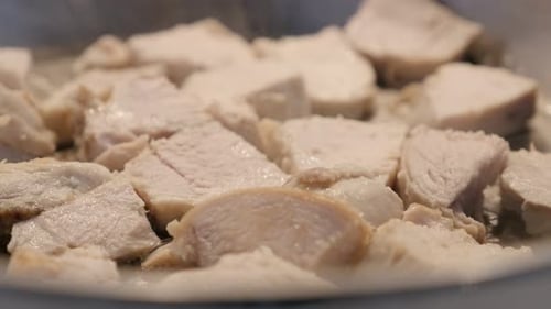 Fresh chicken meat in the pan close-up 4K 2160p 30fps UltraHD video - Cuts of poultry frying on hot