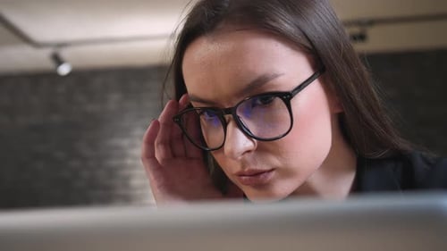 Young Woman Works on a Laptop in the Office