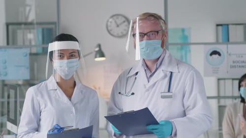 Portrait of Doctors in Protective Uniform at Work in Medical Office
