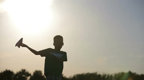 Child with Paper Airplanes at Sunset