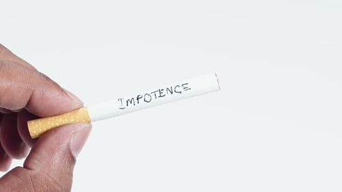 Les doigts tiennent une cigarette avec impuissance à écrire
