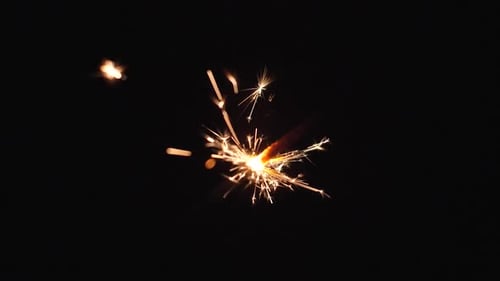 Burning Sparkler Emitting Golden Sparks at Night