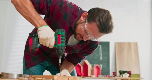 Man Drilling Screw into Wood with Power Drill