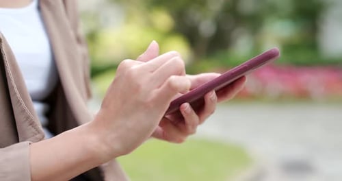 Woman Using Mobile Phone in Urban Park Setting