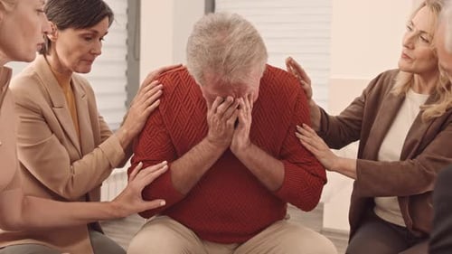 Supportive People Comforting Senior Adult in Group Therapy