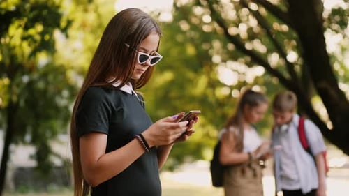 Girl Uses Smartphone in the Park