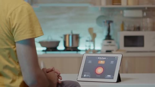 Man Uses Tablet to Control Smart Home System