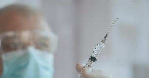 Arzt bereitet Spritze vor. Arzt bereitet Spritze für die Injektion vor. Ärztin oder Krankenschwester Holding