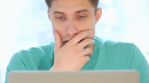 Thoughtful Man Looking at Laptop Screen