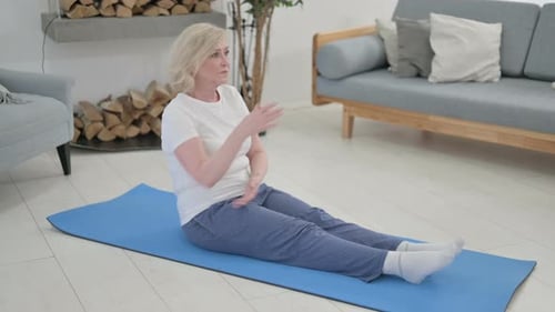 Adult Woman Stretches on Exercise Mat at Home