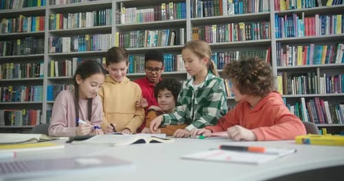 Kids Draw with Markers in Sketchbook at Table in Library