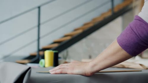 Closeup of Female Hands Drawing on Fabric Working in Studio Sewing Fashionable Garment