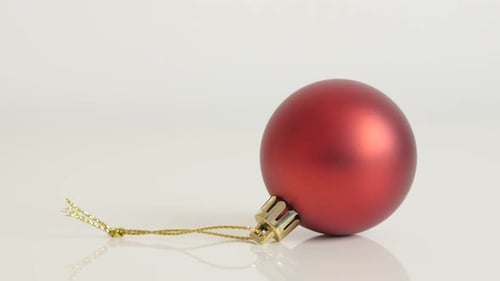 Matte red color shiny bauble close-up 4K 2160p 30fps UltraHD footage - Christmas ornament on white b