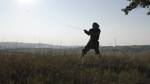 Warrior Practicing with Sword in Rural Field