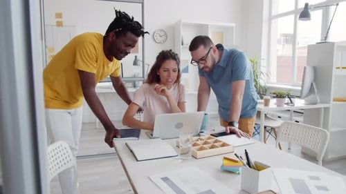 Team Collaborating on a Laptop in Modern Office