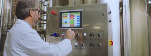 Man Operating Control Panel in Modern Factory